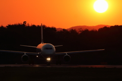夕日は地に沈み、飛行機は空へ立つ