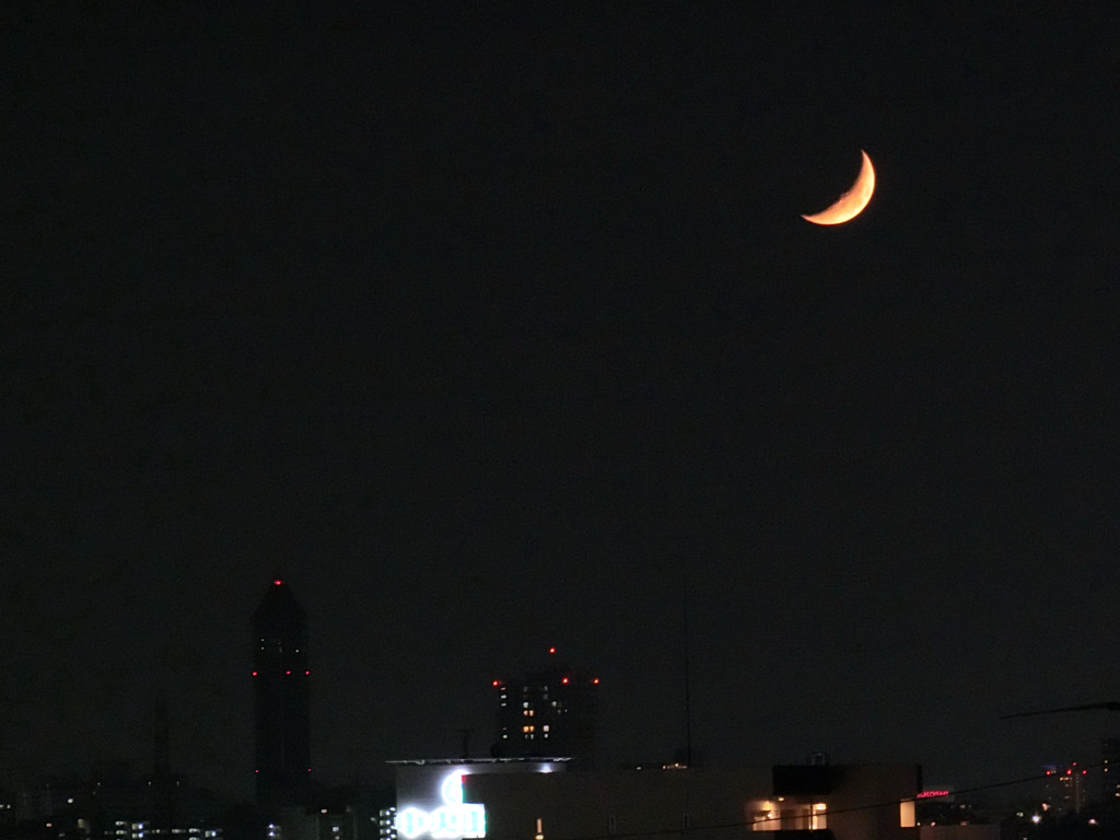 秋の夜空にオレンジ色の三ヶ月