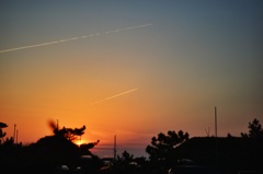夕日に飛行機雲