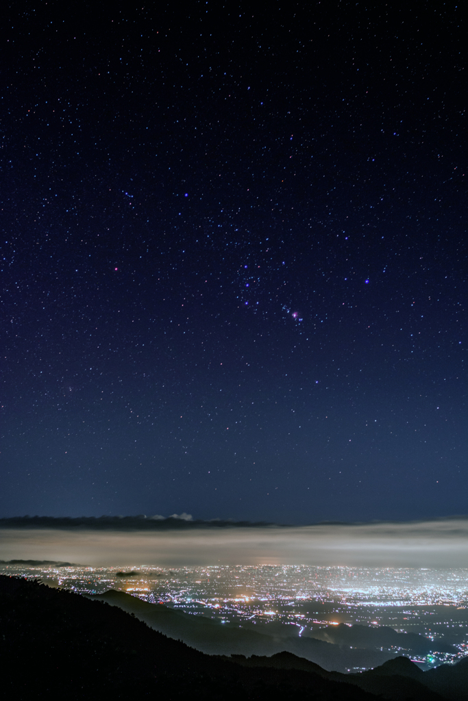 夜景の上のオリオン座