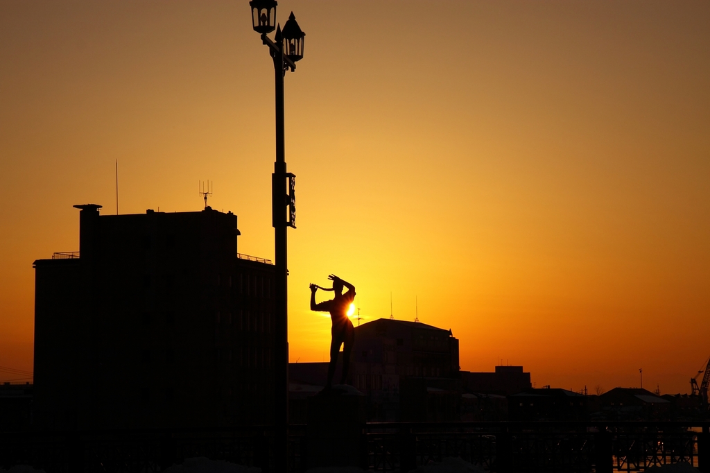 夕日と女像