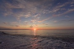 押し寄せる波と夕陽と