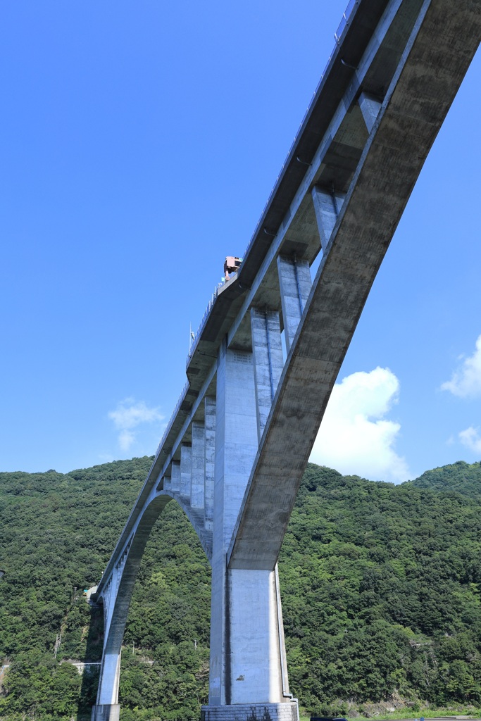 高速道路の橋脚と山間の青空・・・