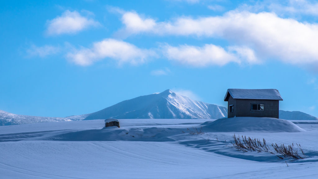 白くなった小屋と山。