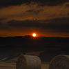 麦稈ロールを照らす夕陽。