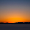 雪積もる畑、夕陽に照らされ。