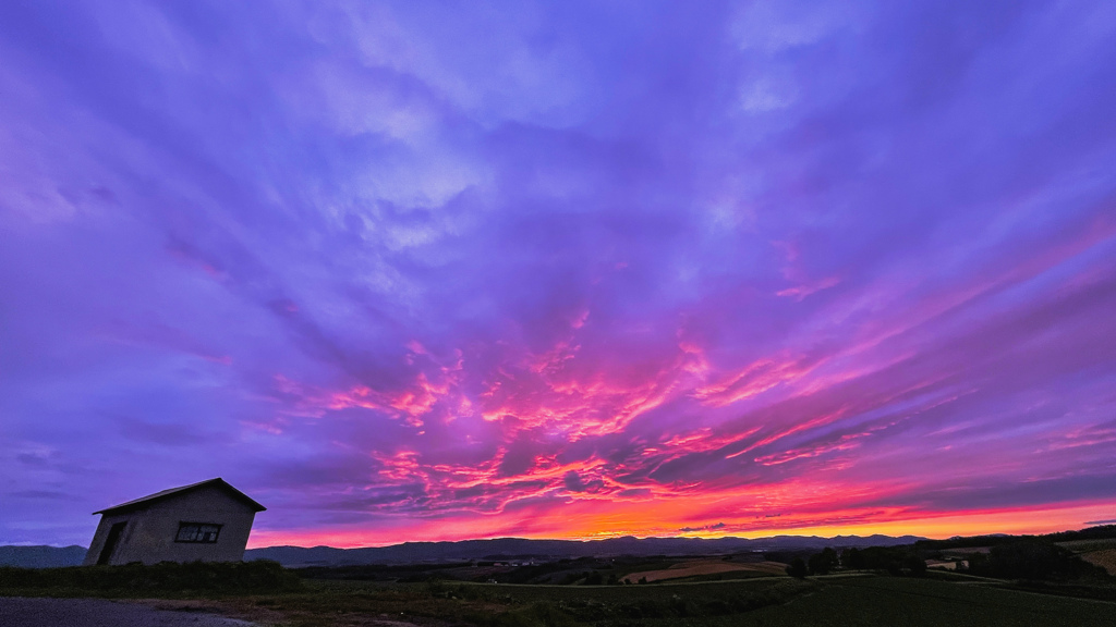 丘の小屋と夕焼け。