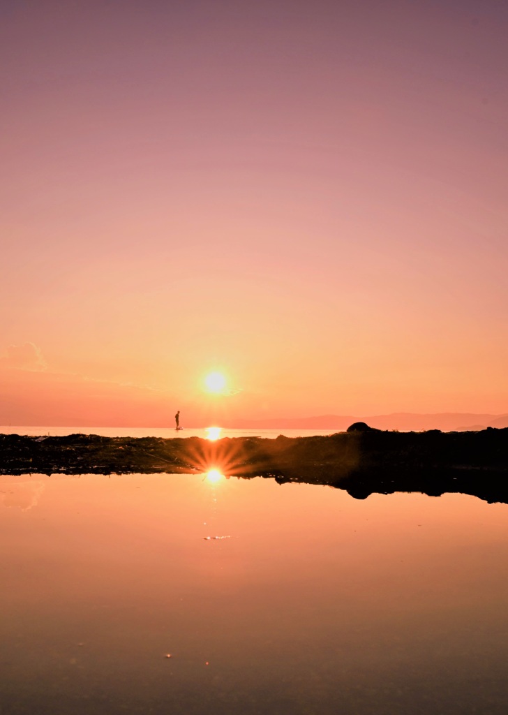 水面から昇る夕陽