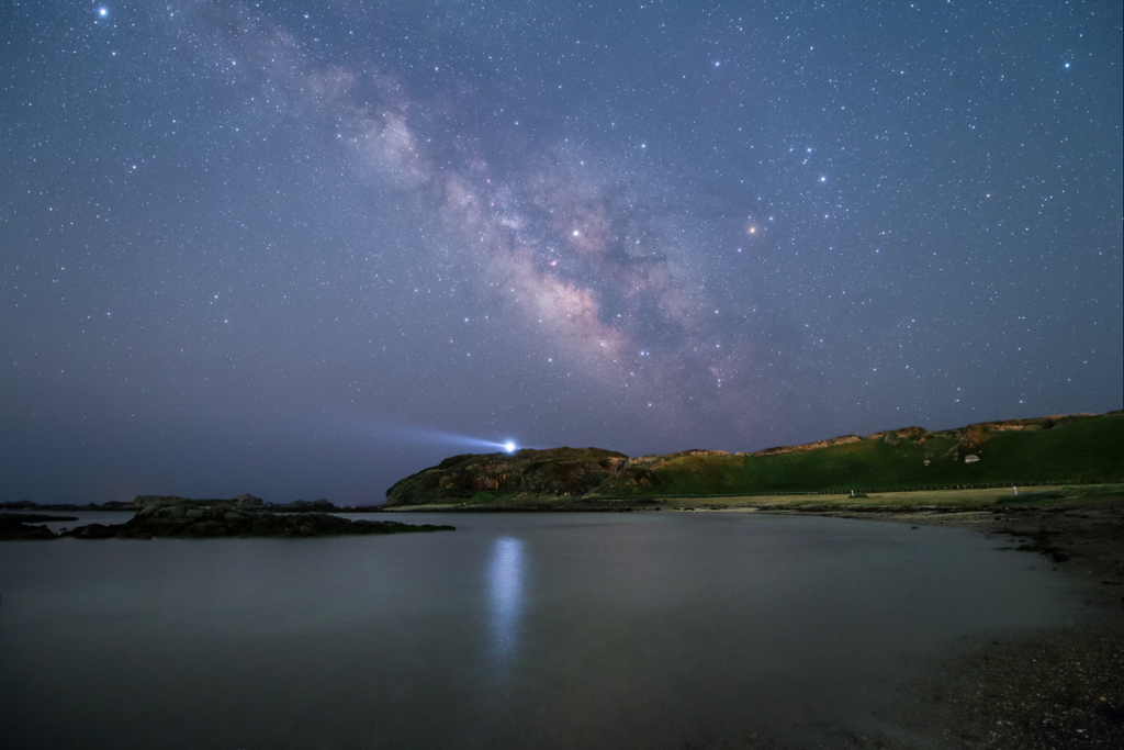 灯台のある入り江と星空