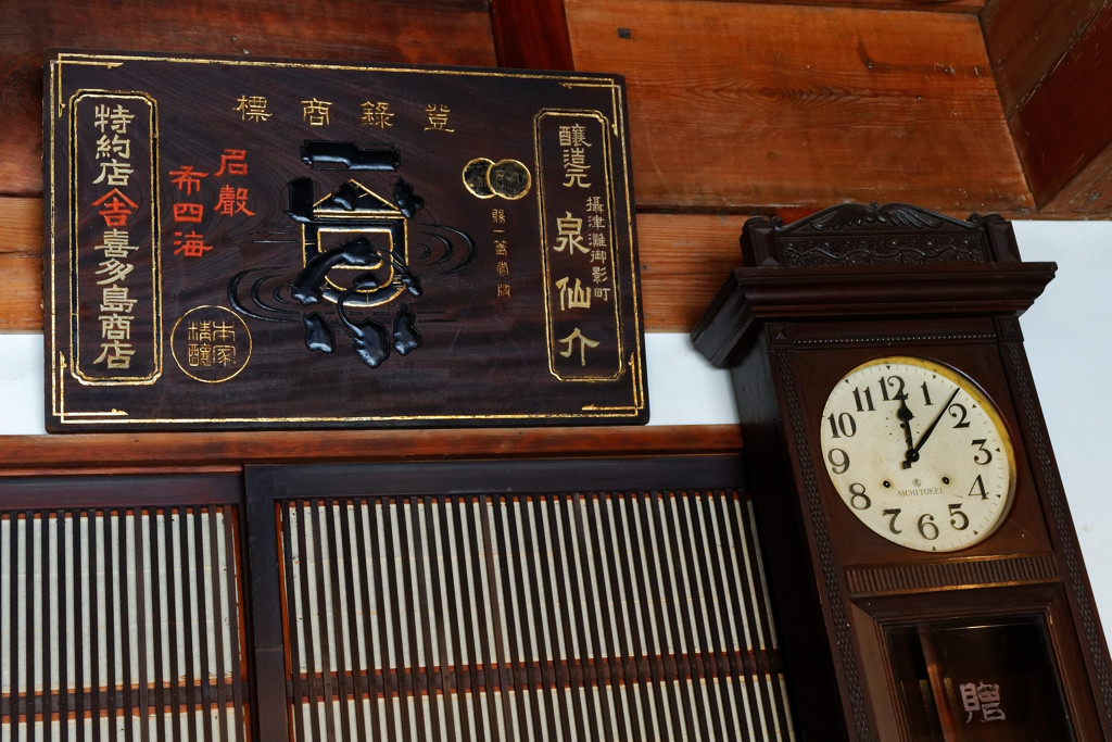 古い木の看板と時計　谷中旧吉田屋酒店にて