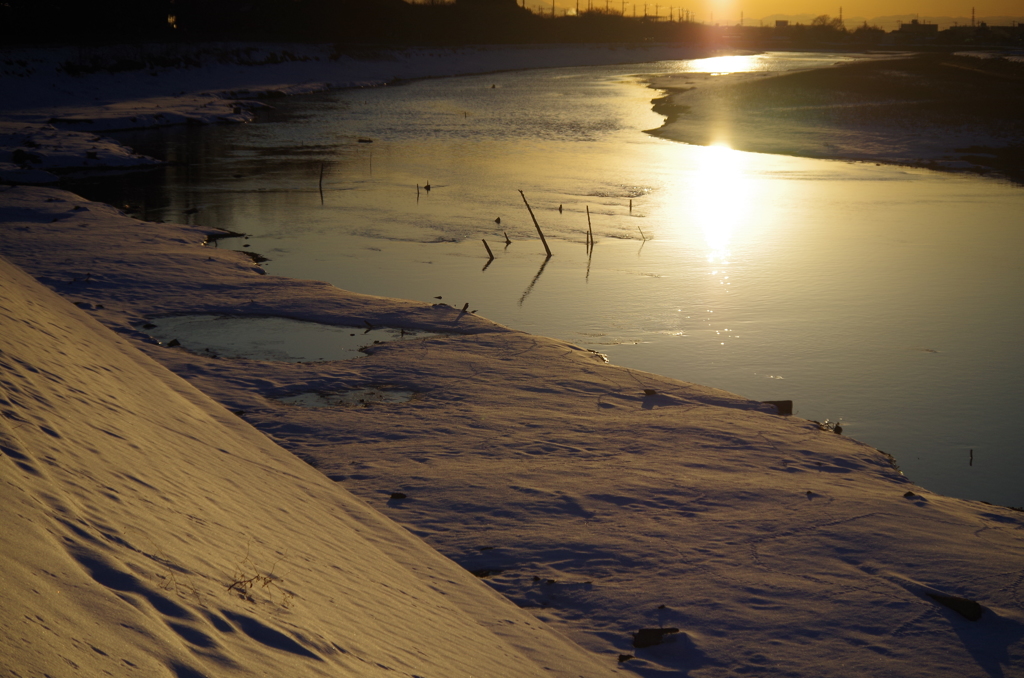川面に映える夕陽と残雪