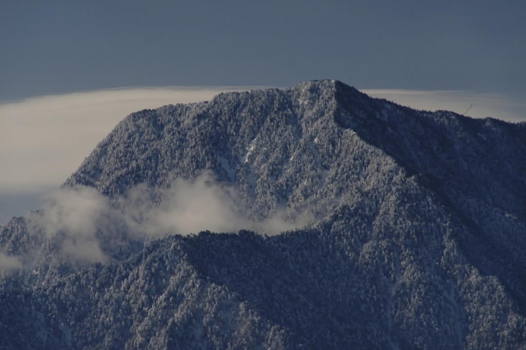 雪煙る有明山