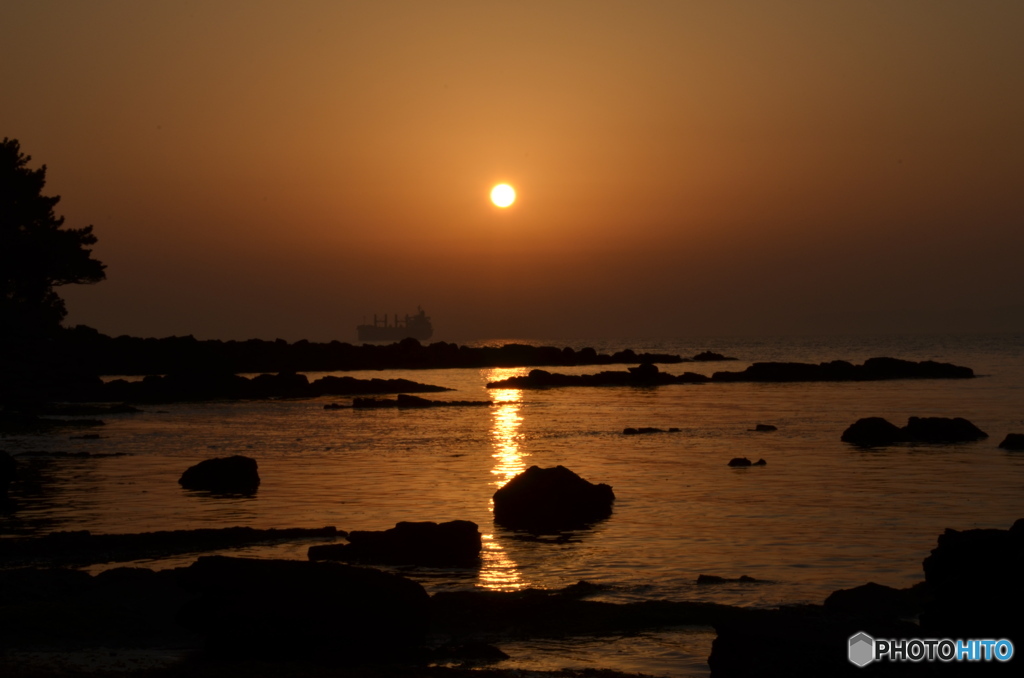 夕日、光りの道と船。