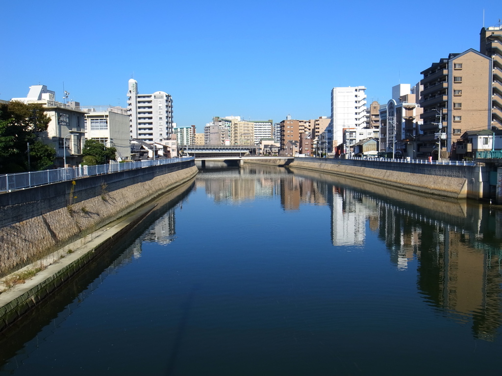 水に映る街、快晴の空