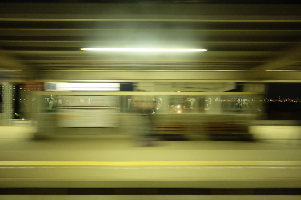 走る電車の窓から駅を撮る