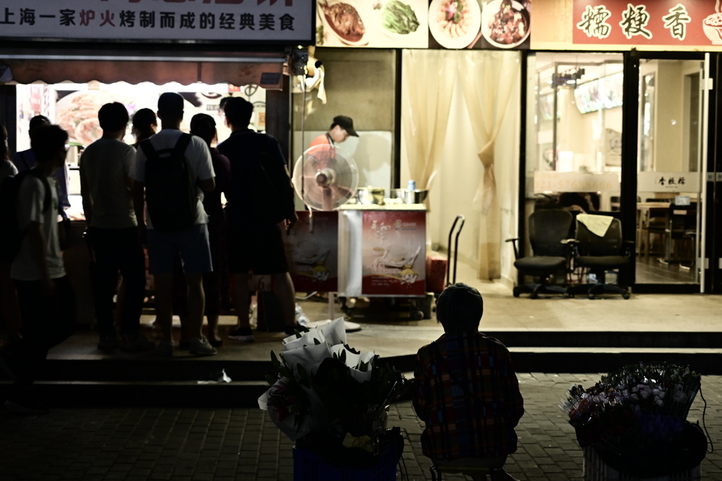 花を売る女性と出店に並ぶ客