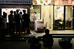 花を売る女性と出店に並ぶ客