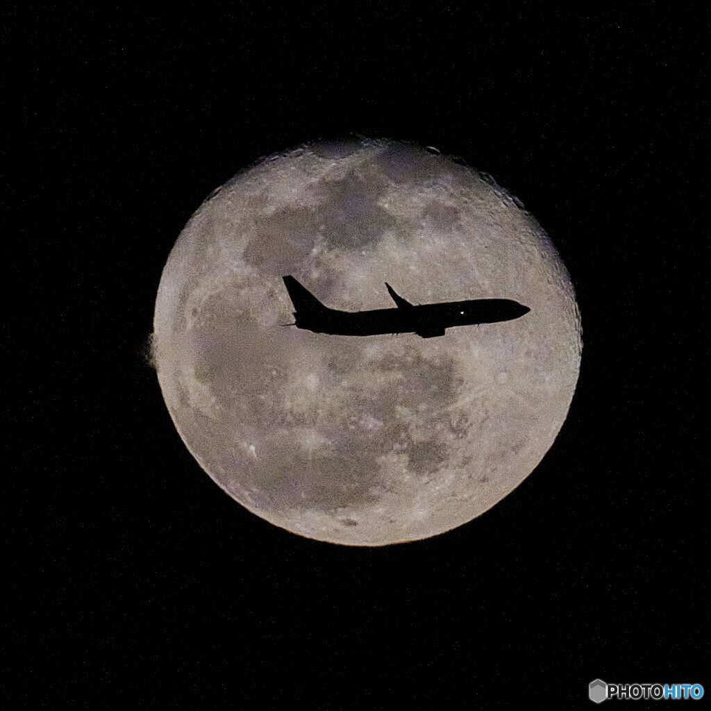 月を横切る飛行機