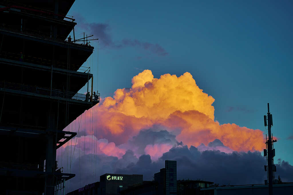 建設現場と夕日を浴びる雲
