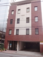 裏の区道を挟んで向かい合って建っている　信徒会館
