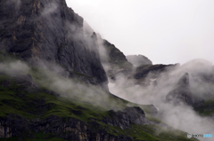 霧の駆け上がるアイガー岩壁