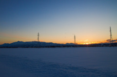 夕焼けと山と雪原