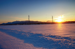 夕焼けと雪原と山