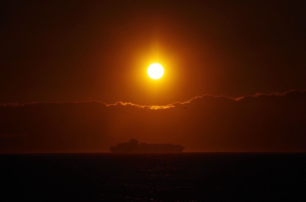 夕日、雲、海、船。