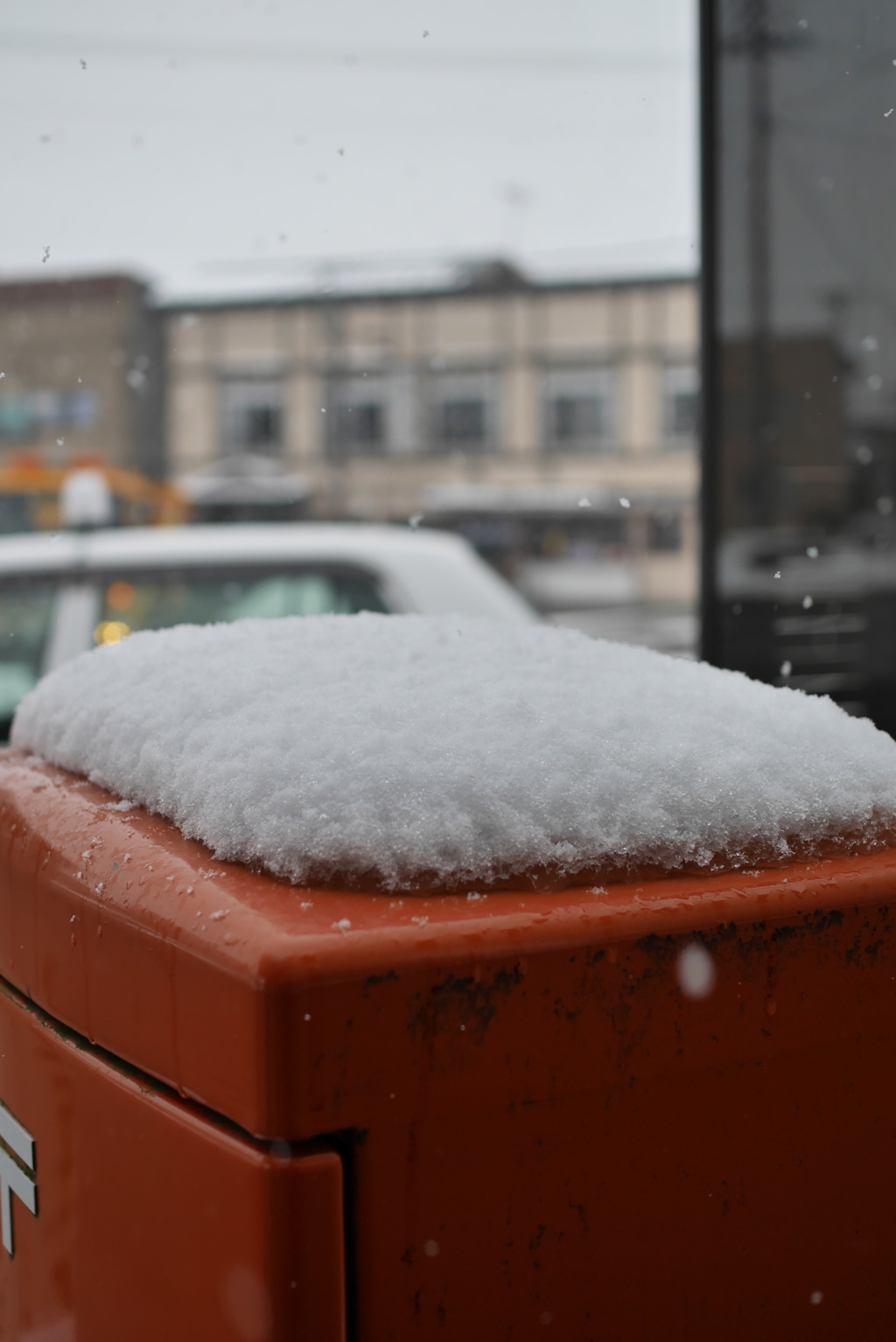 郵便ポストに雪が舞う