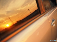 窓に映り込んだ夕焼けを