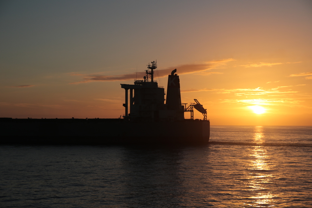 黄昏の海を行くバルクキャリア
