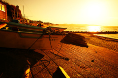 朝陽を浴びる海と漁船
