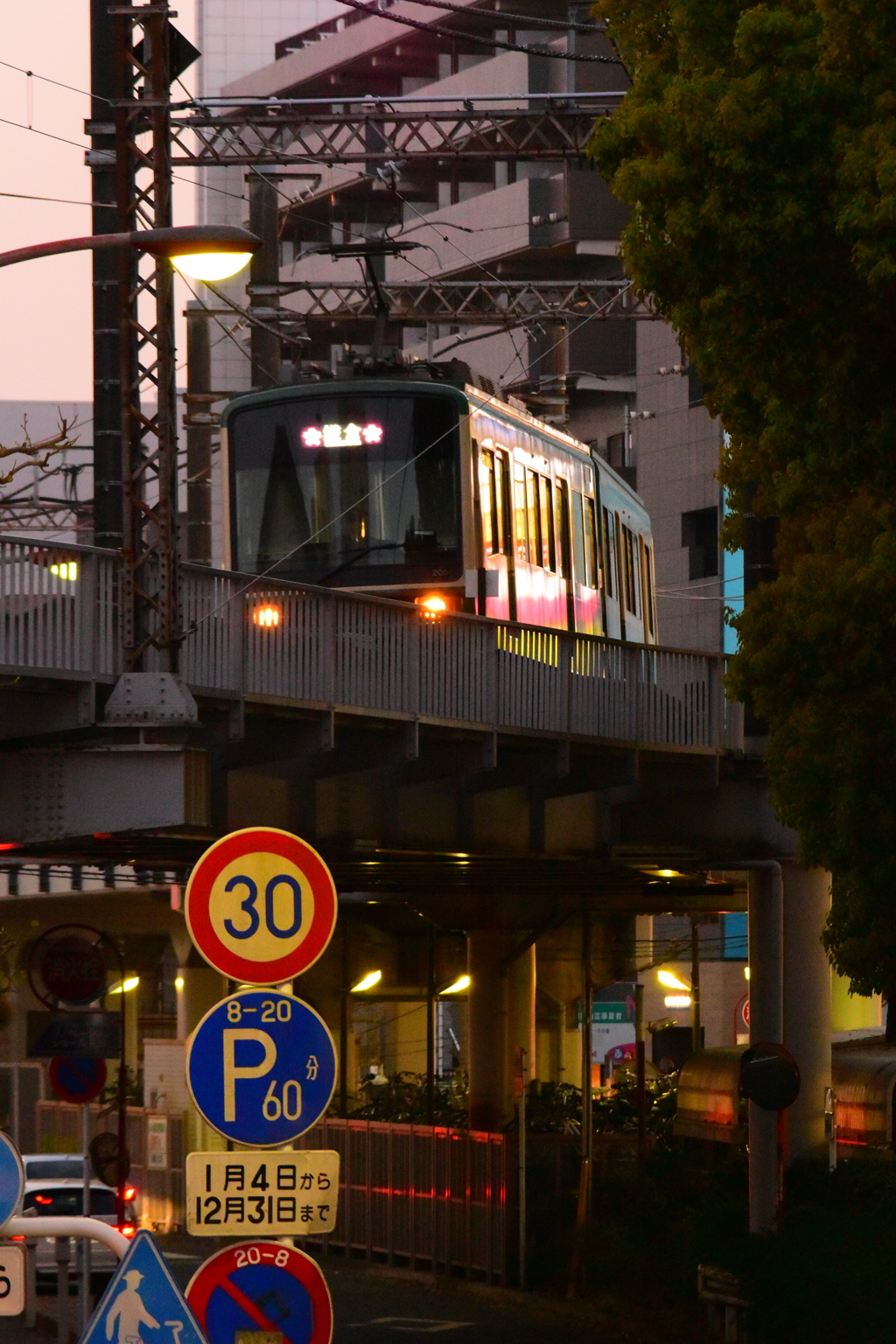 夕暮れの街灯かりを浴びて江ノ電が来た