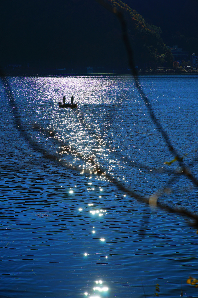 湖面の煌きと釣り人達のシルエット