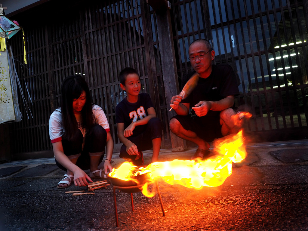 お盆入り迎え火をたく家族