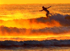 日の出の海霧とサーファー