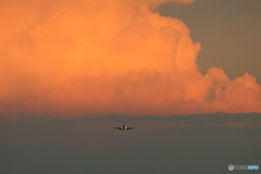 夕陽を浴びる巨大な雲と飛んで来る飛行機たち