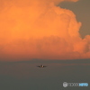 夕陽を浴びる巨大な雲と飛んで来る飛行機たち