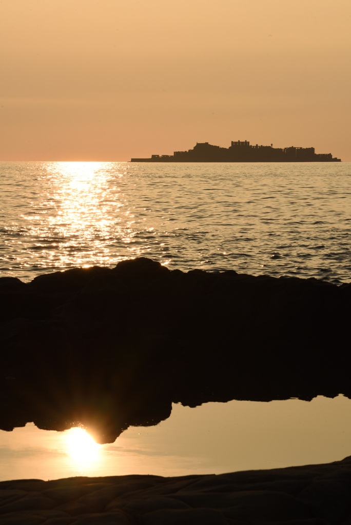潮だまりに映る夕日と軍艦島