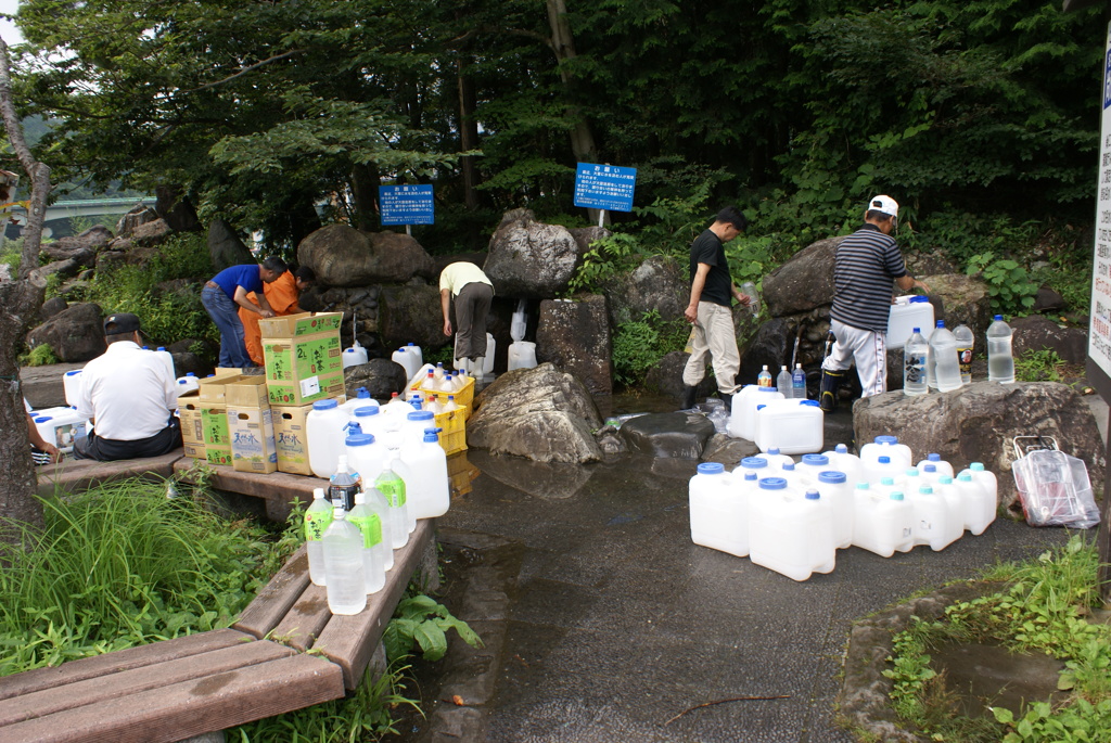 尚仁沢湧水の水を汲む人