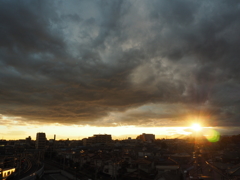 雲と街の間から見える夕日