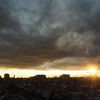 雲と街の間から見える夕日