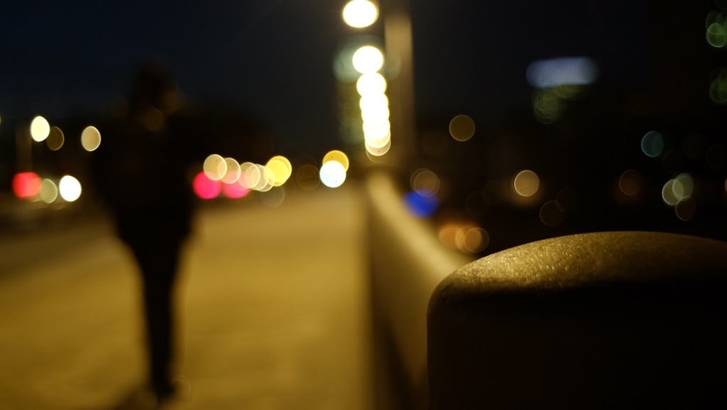 夜の橋を渡る人影