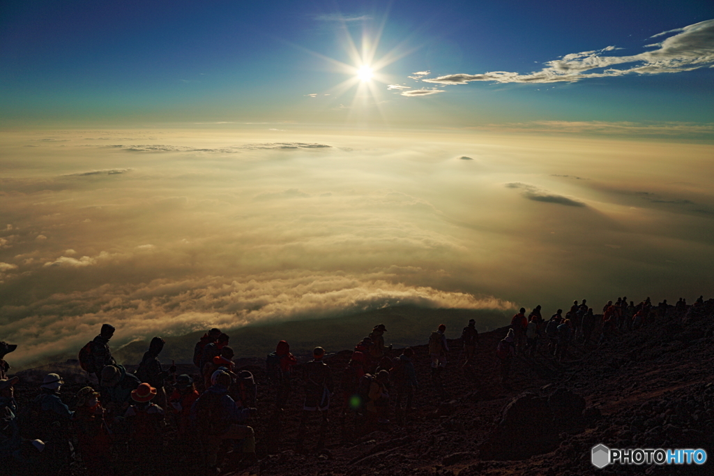 太陽と雲海と登山者