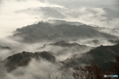 煙る山