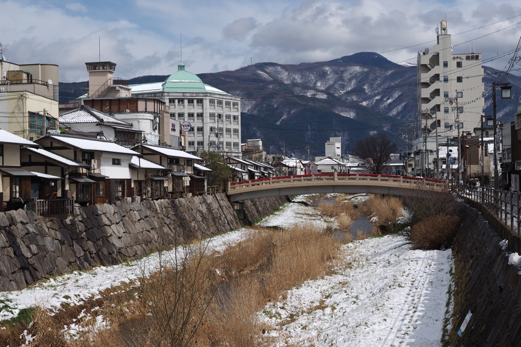 赤い太鼓橋と名残の雪