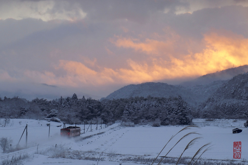 夕焼け雲と雪煙