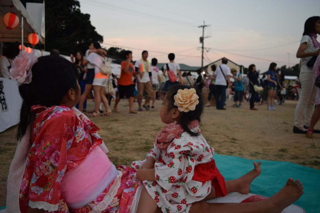 祭りの夕暮れに佇む怪獣姉妹