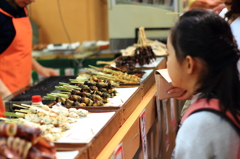 焼きイカ販売を見つめる少女