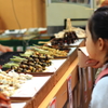 焼きイカ販売を見つめる少女